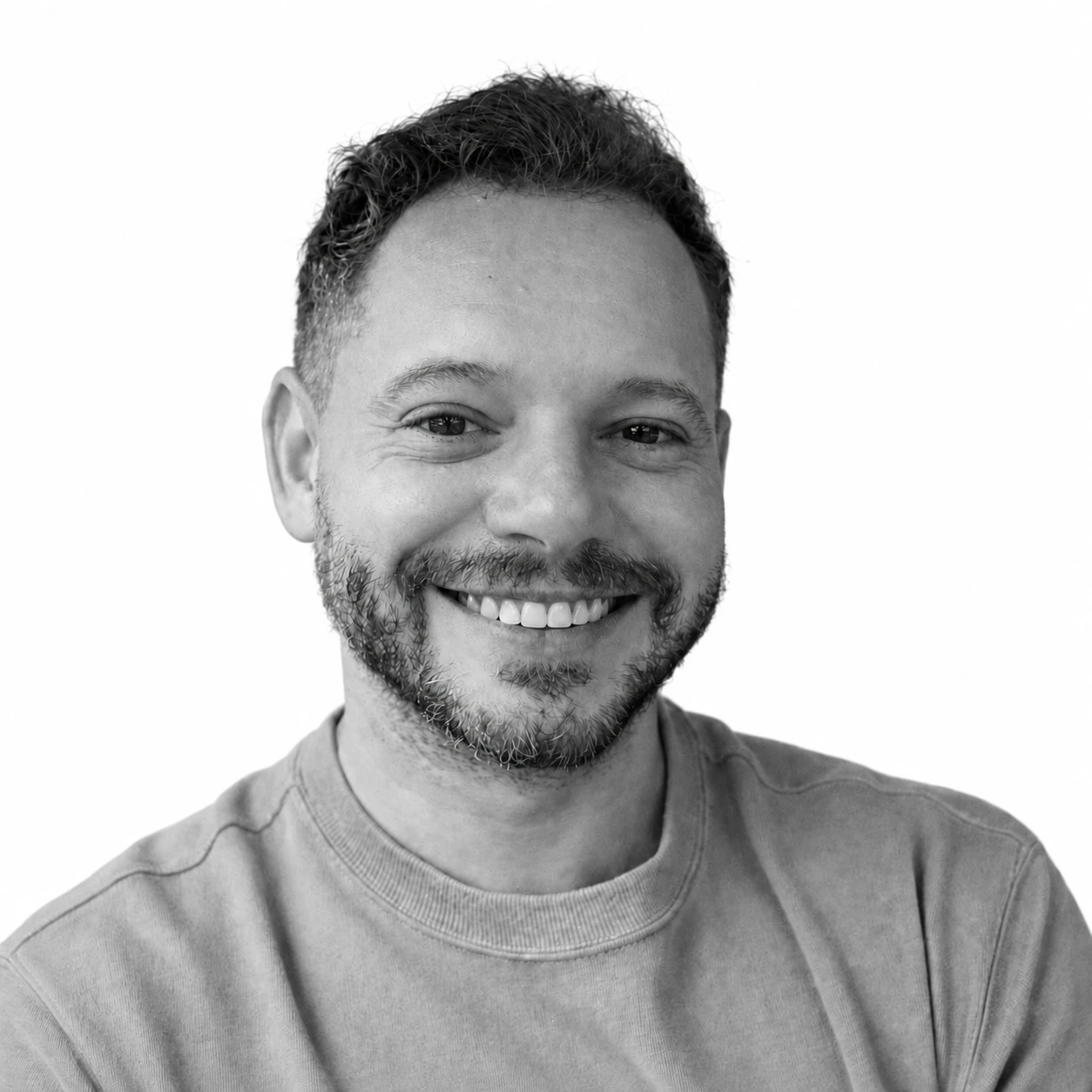 Daniel Cozma smiling in a monochrome portrait against a plain grey background